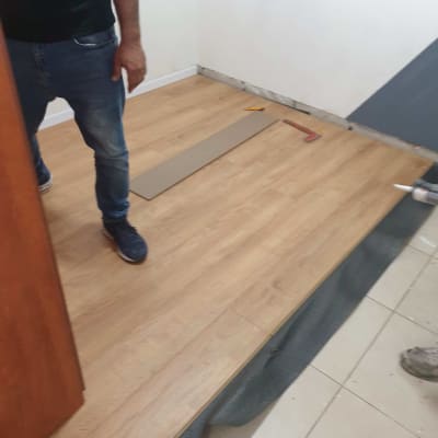 התקנת פרקט עץ בחדר עם כלים על הרצפה