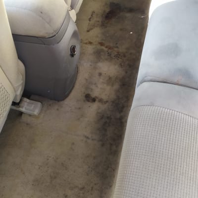 ריפוד רכב מלוכלך עם כתמים כהים על הרצפה