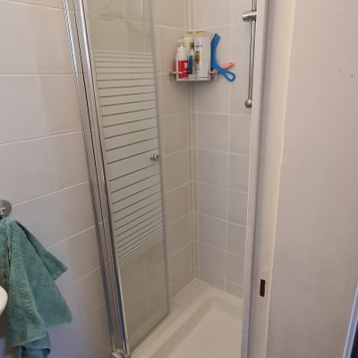 מקלחון עם מדף מוצרים ומגבת תלויה