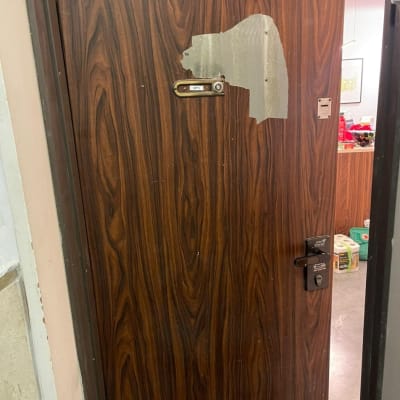 דלת עץ עם ציפוי מתקלף וחור למנעול