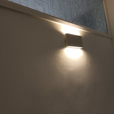 מנורת קיר דולקת על קיר חלק