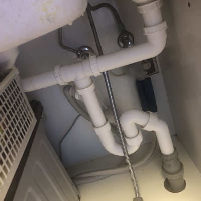 צנרת פלסטיק לבנה מתחת לכיור עם חיבורים