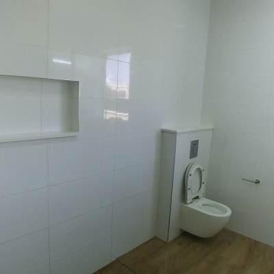 חדר אמבטיה עם מקלחת, שירותים ורצפת עץ