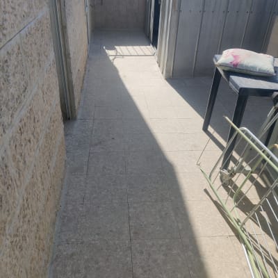 מרפסת עם קירות אבן ורצפת אריחים