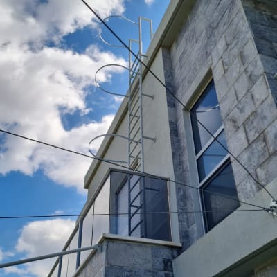 סולם מתכת על קיר בניין עם חלונות