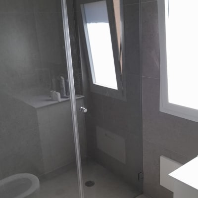 מקלחון זכוכית עם ראש מקלחת עגול ומדף מוצרים