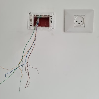 חוטי רשת יוצאים מקופסת חיבורים בקיר