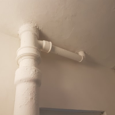 צינור צבוע בלבן על תקרה וקיר