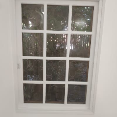 חלון עם מסגרת לבנה וקירות צבועים בלבן