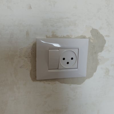 שקע חשמל בקיר עם טיח מתקלף