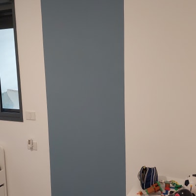 קיר צבוע בכחול כהה ליד שולחן עם חפצים