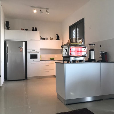 מטבח עם מקרר, תנור ומכונת קפה על אי