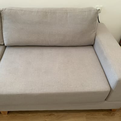 ספה אפורה עם כריות על רצפת עץ