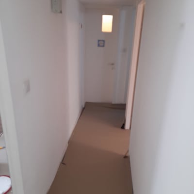 מסדרון עם קירות צבועים בלבן ונייר חום על הרצפה