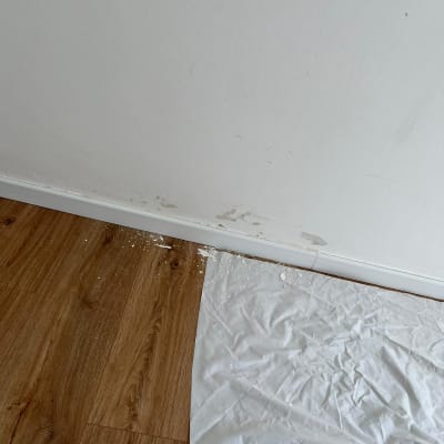 קיר צבוע עם כתמי צבע על הרצפה