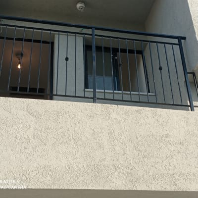 מעקה ברזל שחור במרפסת עם חלון פתוח