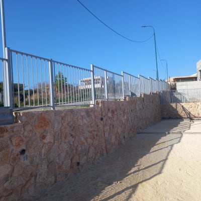 קיר אבן עם צינורות השקיה בגינה