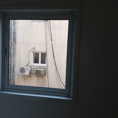 חלון אלומיניום לבן בודד מותקן בחדר בבית