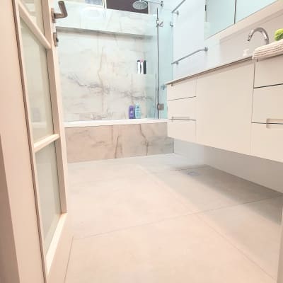 חדר אמבטיה משופץ עם מקלחון זכוכית וברזים חדשים