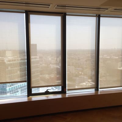 וילונות גלילה לבנים על חלונות זכוכית גבוהים