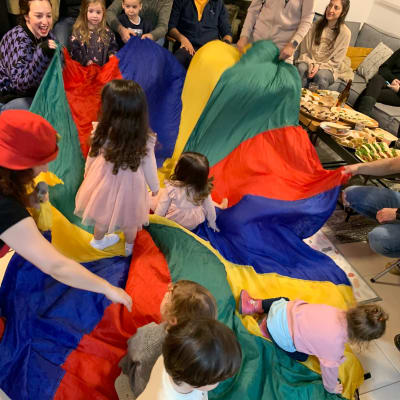 ילדים משחקים עם מצנח צבעוני במסיבת יום הולדת