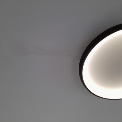 מנורת תקרה עגולה מוארת על קיר לבן