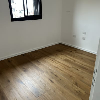 רצפת פרקט עץ בחדר ריק עם חלון