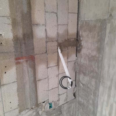 צינור מיזוג אוויר בקיר בטון עם חיבורים חשופים