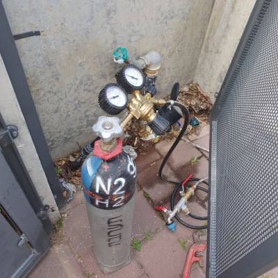 בלון גז עם מד לחץ וכלי עבודה של אינסטלטור