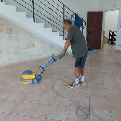 אדם מנקה רצפה עם מכונת פוליש חשמלית