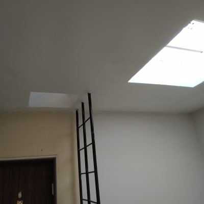 סולם צמוד לקיר לבן עם חלון תקרה