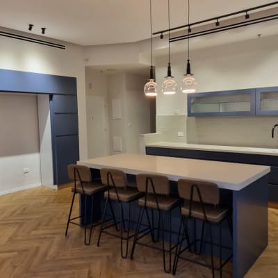 מטבח מודרני עם אי, כיסאות ותאורה תלויה