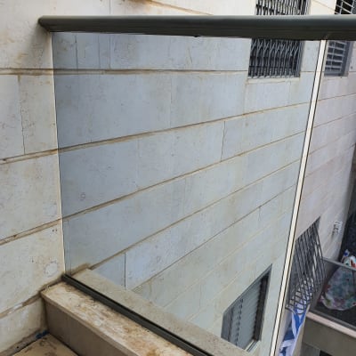 מעקה זכוכית עם מסגרת מתכת על מרפסת