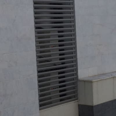 תריסים אפורים על חלון בניין לבן