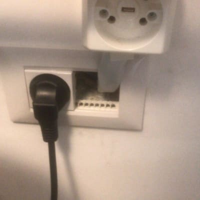 שקע חשמל עם תקע מחובר וקופסת חיבורים פתוחה