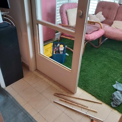 דלת עם זכוכית חסרה וכלי עבודה על הרצפה