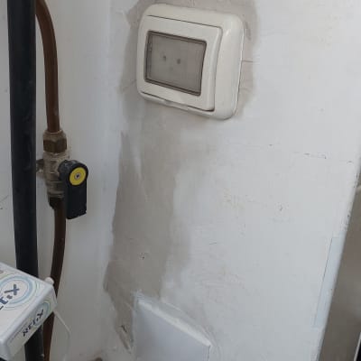 מד חשמל מותקן על קיר עם צינורות