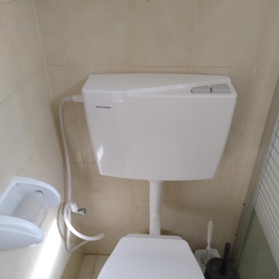 מיכל הדחה לבן עם צינור מים מחובר