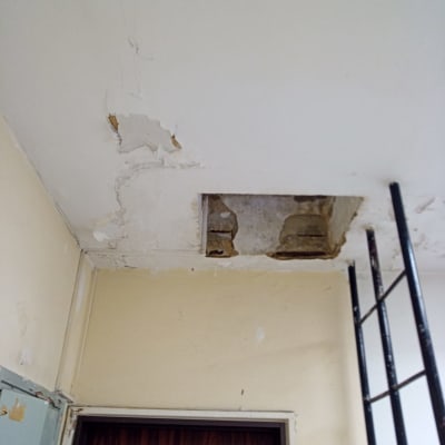 תקרה מתקלפת עם חור ותיקוני צבע