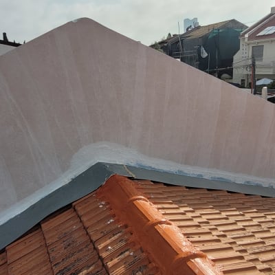 גג רעפים אדום עם קיר בטון צבוע לבן