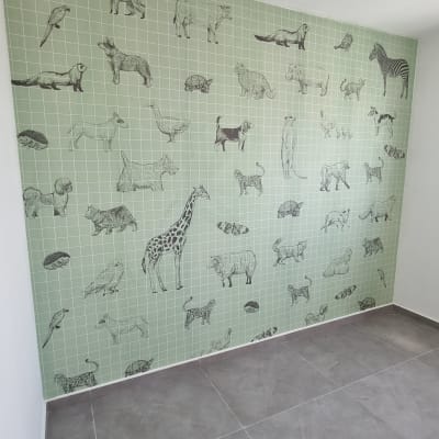 קיר עם טפט ירוק ודוגמאות של חיות שונות