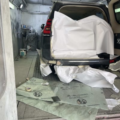 רכב בתהליך תיקון פחחות עם נייר מגן על הדלת האחורית