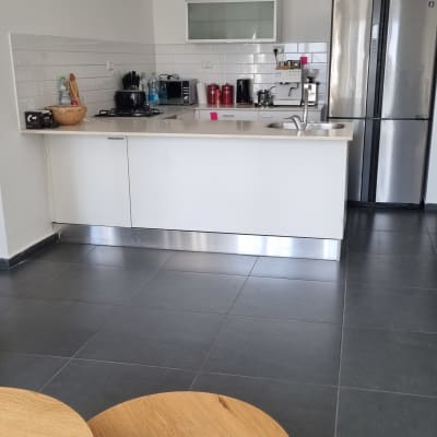 מטבח מאורגן עם מקרר, כיור ומכונת קפה