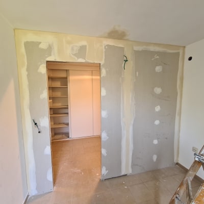 קיר גבס עם תיקוני שפכטל וסולם עץ