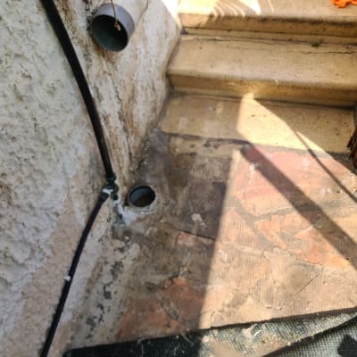 צינור פלסטיק ליד פתח ניקוז על רצפה