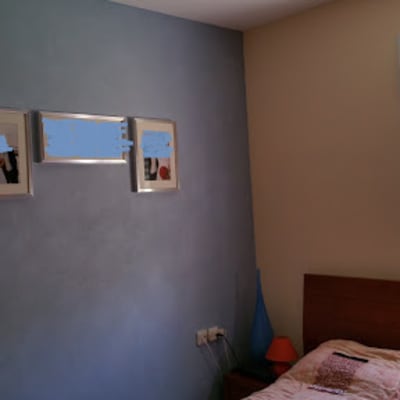 קיר צבוע בכחול עם שלוש תמונות ממוסגרות