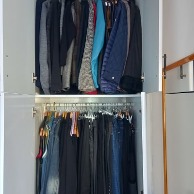 ארון בגדים מסודר עם מעילים ומכנסיים על קולבים