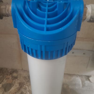 פילטר מים כחול ולבן מחובר לצינור