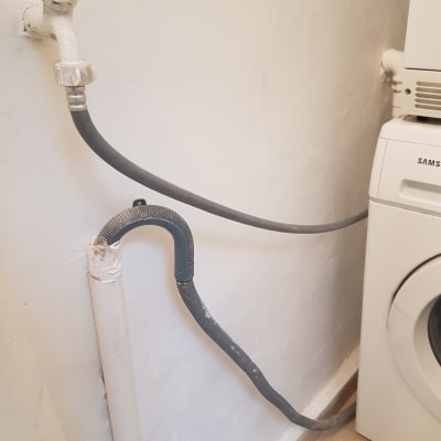 צינור מים מחובר לברז על קיר צבוע