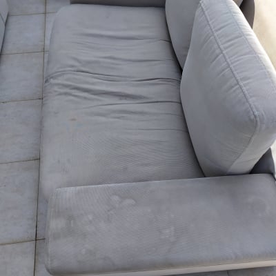 ספה אפורה עם כתמים על הריפוד